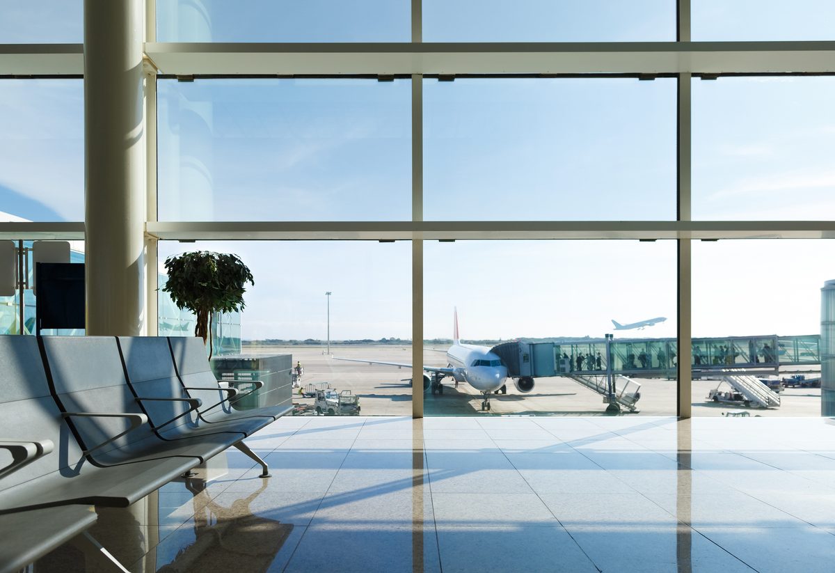 Lufthavnsterminal med udsigt til et fly gennem vinduet